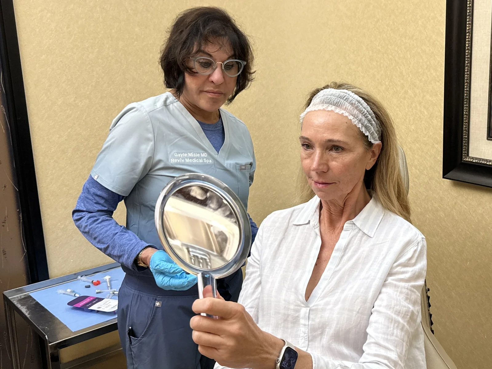 Dr. Gayle Misle showing a patient her result in a hand mirror